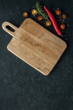 Kesme tahtası, baharat, biber, domates ve diğer malzemelerle dikey arka plan. Metin için yer