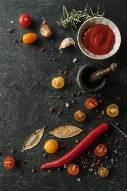 Baharatlar, biber, domates sosu ve diğer malzemelerle birlikte dikey bir arka plan. Üst görünüm