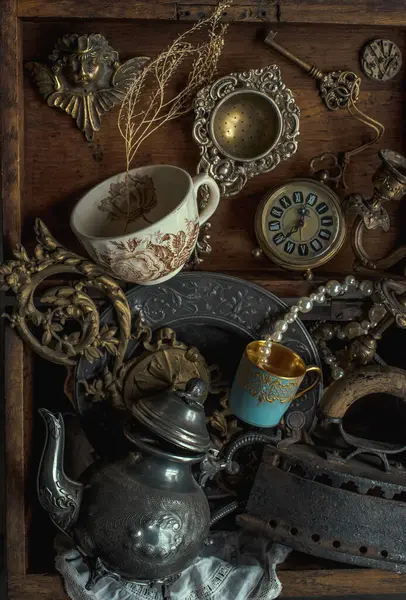 Antique treasures in a wooden box at a flea market. Vintage background with old rare things