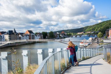 Esplanade of Grognon in Namur, Belgium. Cycle-pedestrian bridge between Jambes and Namur, Wallonie, Belgium. A woman and a boy look at the Meuse River in the city of Namur clipart