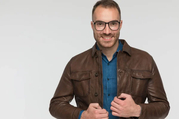 Jovem Homem Casual Organizando Seu Casaco Vestindo Óculos Sorrindo Para — Fotografia de Stock