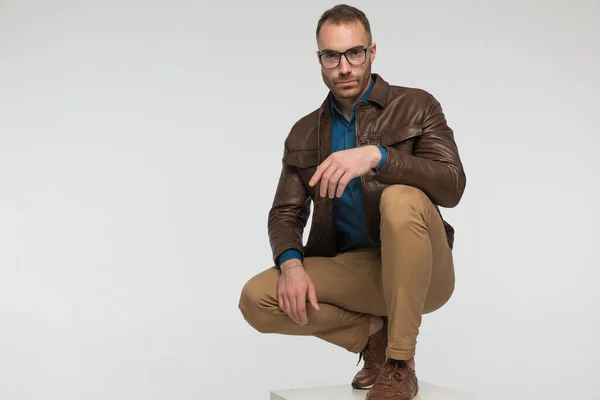 Serious Casual Man Squatting Tough Look Wearing Brown Leather Jacket — Stock Photo, Image