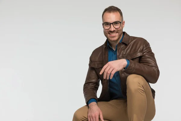 Handsome Casual Man Smiling While Squatting Wearing Brown Leather Jacket — Stock Photo, Image