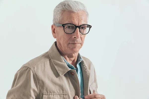 Zbliżyć Się Starego Niezobowiązującego Mężczyzny Układającego Kurtkę Noszącego Okulary Szarym — Zdjęcie stockowe