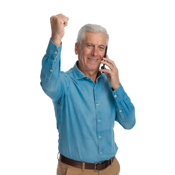 Vecchio Entusiasta Che Parla Telefono Celebra Vittoria Con Pugno Davanti — Foto Stock
