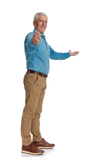 Feliz Anciano Señalando Con Dedo Presentando Lado Mientras Sonríe Pie —  Fotos de Stock