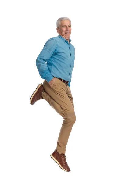 Gelukkig Man Springen Lucht Met Handen Zakken Glimlachen Voorkant Van — Stockfoto