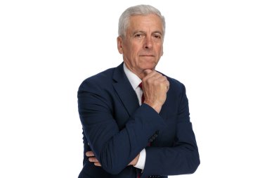 Businessman in his 60s scratching his chin while being pensive