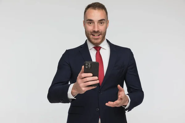 Sexy Young Businessman Holding Telephone Scrolling Social Media Front Grey — Stok fotoğraf