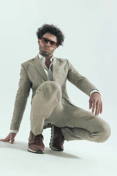 Cool Arabic Man Curly Hair Crouching Touching Floor While Posing — Stock Photo, Image