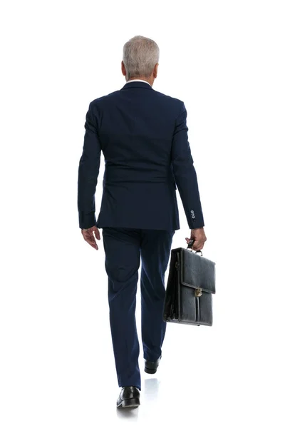 全身像と手にブリーフケースを持って歩く古いビジネスマンのリアビュー — ストック写真