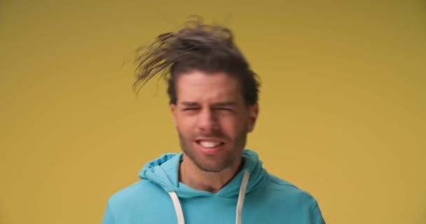 拍摄了一段关于一头卷曲的长发 做傻脸 在黄色背景下笑的帅哥的视频 — 图库视频影像