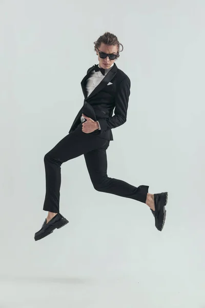 Side View Sexy Man Elegant Tuxedo Sunglasses Jumping Air Making — Stock Photo, Image