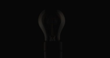 project video of light bulb slightly turning on, saving electric energy because prices are high, concept of monotony and plainness
