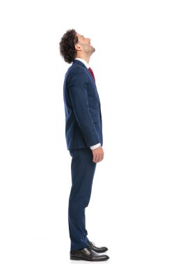 side view picture of elegant arabic businessman looking up and laughing while standing and posing on white background in studio