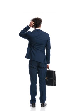 confused young man scratching head and thinking of solving problems in front of white background in studio