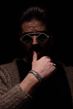 Portrait of sexy casual man pressing his lips with masculine frame, standing, in a fashion pose