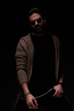 Portrait of sexy man posing with hands around body in a sexy stance, standing, in a fashion pose