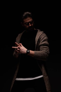 Portrait of handsome guy crossing his fingers with dramatic stance, standing, in a fashion pose