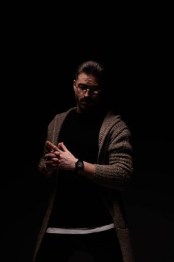 Portrait of attractive man crossing his fingers with cool style, standing, in a fashion pose