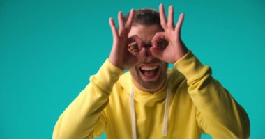 happy casual man gesturing finger eyeglasses, giving a thumbs up and fooling around