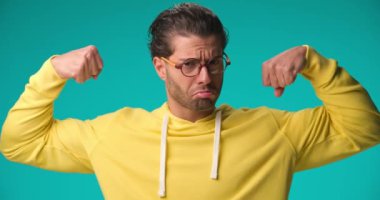 young casual man flexing his arms like a bodybuilder