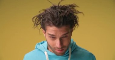 casual man shaking his hair then gesturing a faint