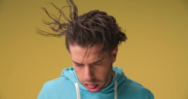 handsome casual man shaking his head from side to side and sticking out his tongue