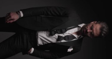 Smokinli ve papyonlu seksi iş adamı ciddiyetten gülmeye ve eğlenmeye geçiyor.