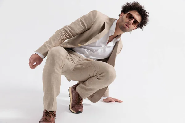 Sexy Smart Casual Guy Wearing Sunglasses Crouching Touching Ground Front — Stock Photo, Image