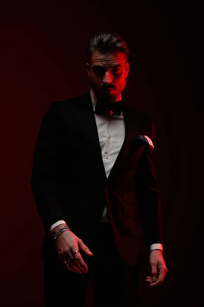 Уверенно Элегантный Человек Черном Смокинге Позирует Моде Красными Огнями — стоковое фото