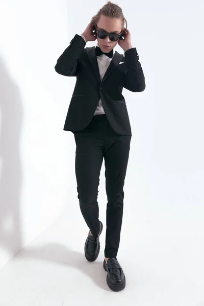 Sexy Young Man Tuxedo Sunglasses Adjusting Hair Walking Front Grey — Stock Photo, Image