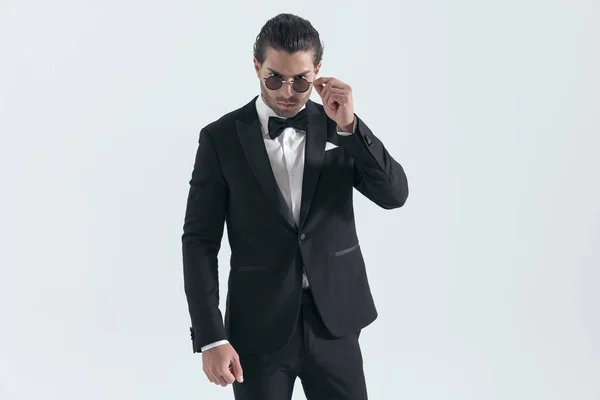 Elegant Groom Black Tuxedo Adjusting Sunglasses Confidently Posing Front Grey — Stock Photo, Image