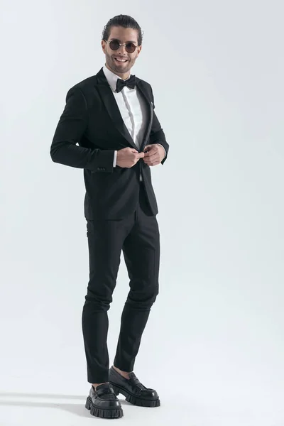 Happy Elegant Man Sunglasses Buttoning Black Tuxedo Smiling Front Grey — Stock Photo, Image