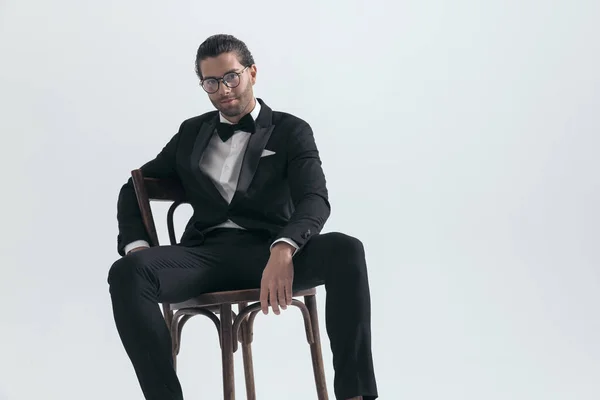 Feliz Joven Elegante Hombre Con Gafas Con Esmoquin Negro Sentado — Foto de Stock