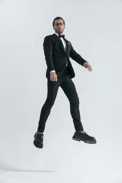 Joven Moda Esmoquin Negro Con Gafas Saltando Aire Sobre Fondo — Foto de Stock
