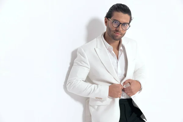 Gözlüklü Yakışıklı Adam Beyaz Ceketin Düğmelerini Açıyor Gri Arka Planda — Stok fotoğraf