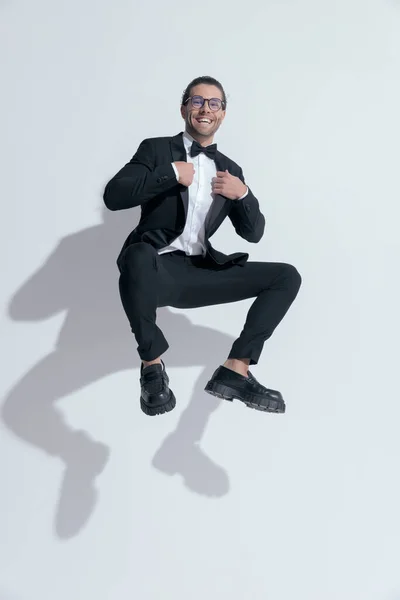 Empresário Sexy Pulando Agachando Enquanto Fixa Seu Smoking Vestindo Óculos — Fotografia de Stock