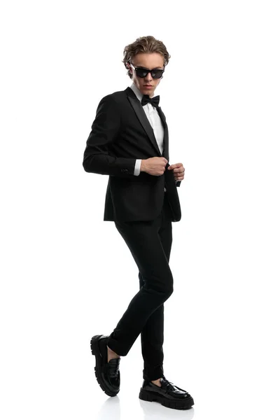 ハンサムなビジネスマンが1本足を折り上着を閉じて白いスタジオの背景に正式な衣装を着て — ストック写真