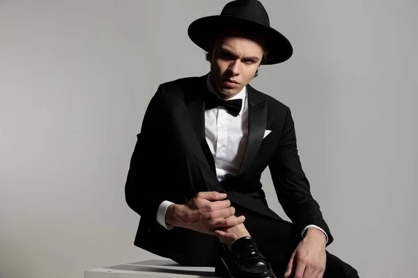 Bonito Elegante Homem Preto Tuxeodo Com Chapéu Segurando Tornozelo Posando — Fotografia de Stock