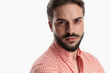 Ekose gömlekli çekici sakallı adamın yakın plan fotoğrafını çek. Stüdyoda beyaz arka plan önünde poz ver.