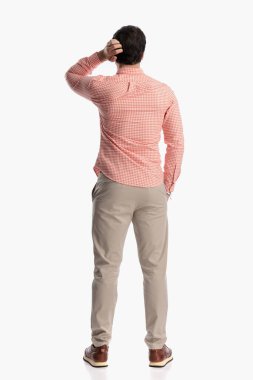 Kafası karışık, ekose gömlekli, kafasını kaşıyan ve beyaz arka plandaki zor sorunları çözmenin yollarını düşünen sıradan bir adamın bakışının ardında.