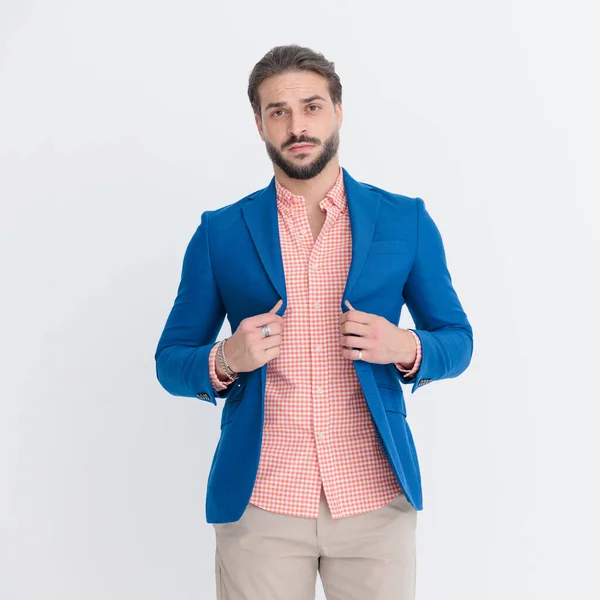 Portrait Confused Young Man Holding Adjusting Blue Jacket While Looking — Stock Photo, Image