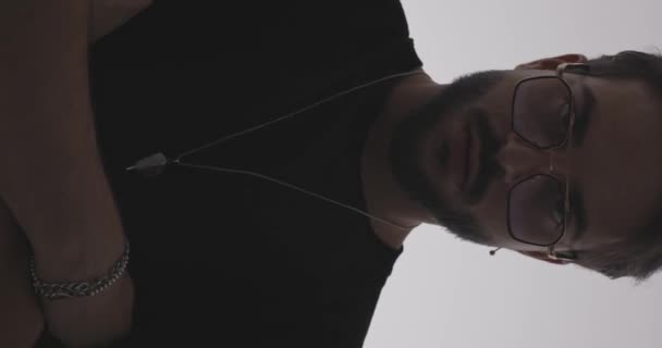 Siyah Tişörtlü Havalı Bir Genç Adamın Dikey Videosu Kollarını Katlıyor — Stok video