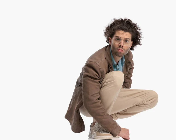 Casual Young Man Curly Hair Looking Forward While Crouching Front — Stock Photo, Image