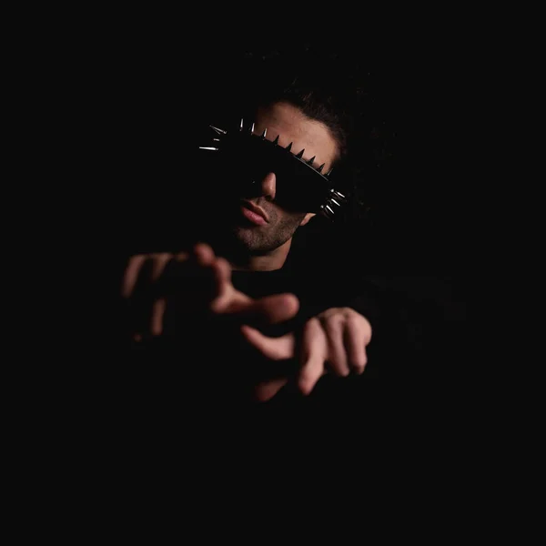 性感而神秘的男人 戴着凉爽的太阳镜 在黑色背景前做手势 指尖着手指 — 图库照片