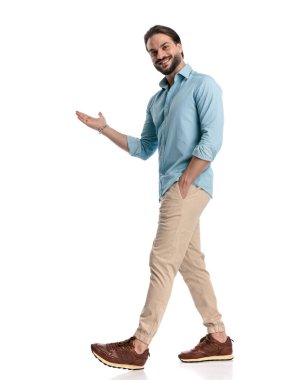 Yandan bakan genç adam el ele yürüyor ve beyaz arka planda hoş karşılanıyor.