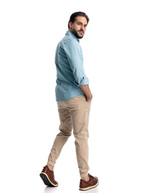 Beyaz arka planda el ele yürürken kendine güvenen genç adam arkasına bakıyor. 