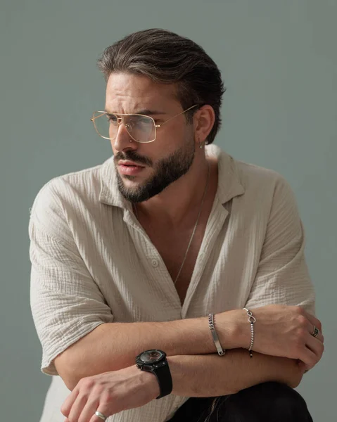 Handsome Bearded Guy Glasses Looking Side Crouching Elbows Knees Front — Stock Photo, Image