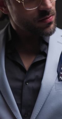 Mendil takan seksi moda adamı, gri arka planda el ele tutuşup el ele tutuşuyor.